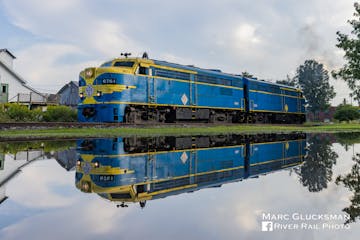 a blue train on a steel track