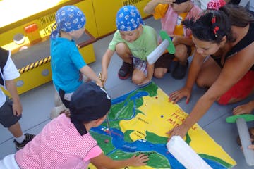 Kids pointing to a treasure map