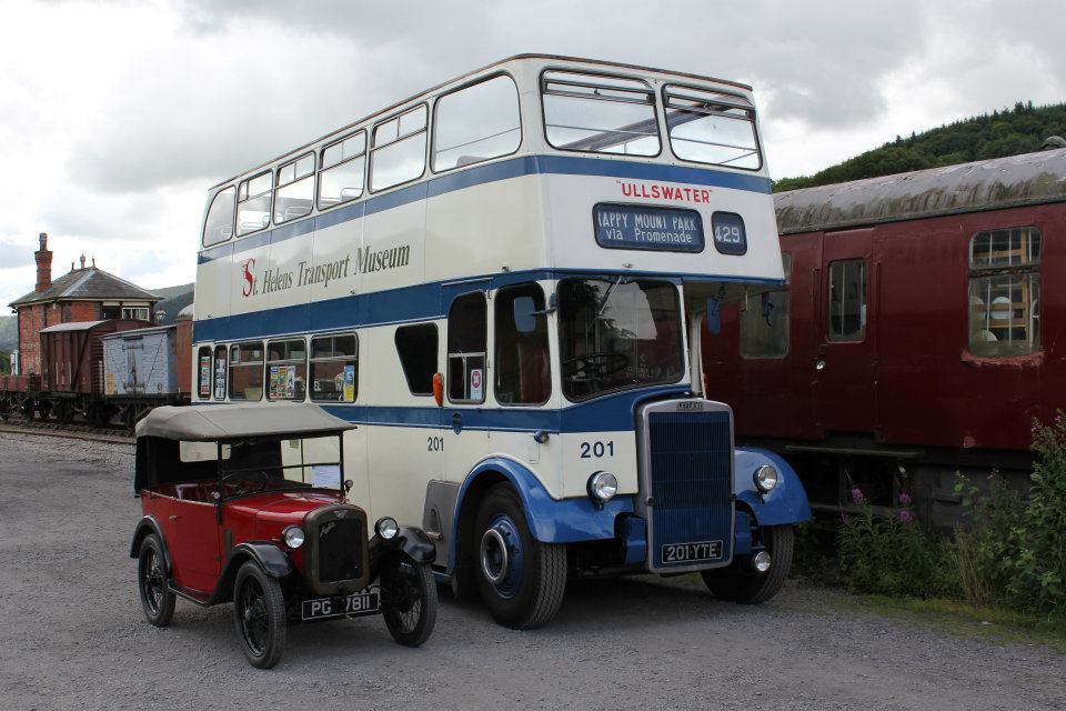 a double decker bus and classic car parked up
