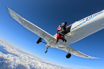 Tandem skydive exits plane above Franz Josef and Fox glacier