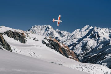 a man flying through the air on a snow covered mountain