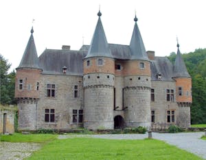 a large brick building with grass in front of a castle
