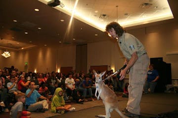 a man and a dog standing in front of a crowd