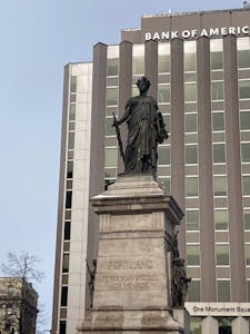 a statue in front of a tall building