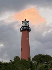 a large tall tower with a clock on the side of Nauset Light