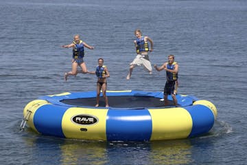 a group of people bouncing on a trampoline in the water