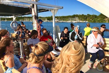 a group of people sitting at a dock in front of a crowd