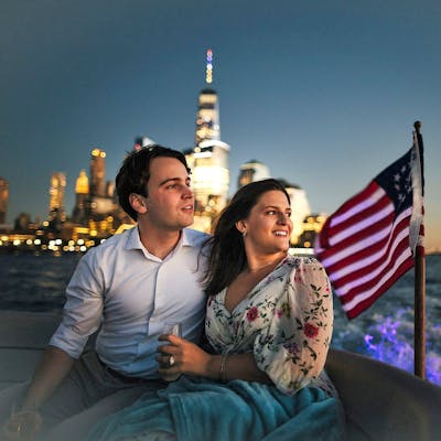 couple on a romantic boat ride with the NYC World Trade Tower and American flag in the background