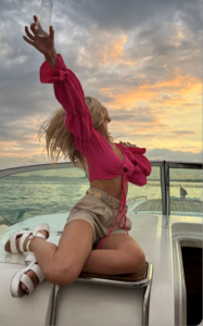 woman in a pink shirt sitting on a yacht rental during sunset cruise nyc private