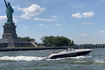 private boat in front of the Statue of Liberty giving a tour