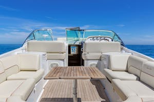 outdoor deck with white cushions and teak deck of a New York yacht charter floating on blue water