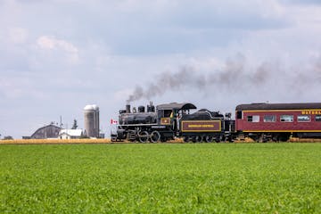 a train traveling down train tracks near a field