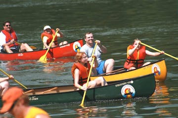 a group of people rowing a boat in the water