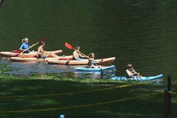 a group of people rowing a boat in a body of water