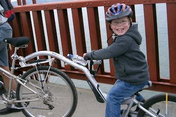 a young child riding on the back of a bicycle