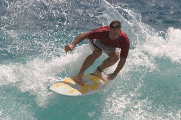 a young man riding a wave on a surfboard in the ocean