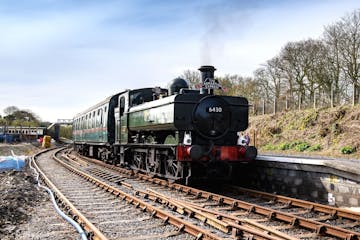 a steam engine train traveling down train tracks