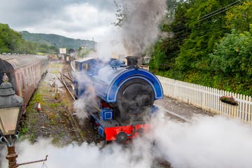 a steam train on a track with smoke coming out of it