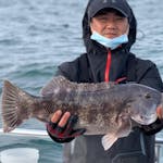 Daisuke Matsuzaka holding a fish in the water