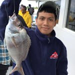 a young boy holding a fish