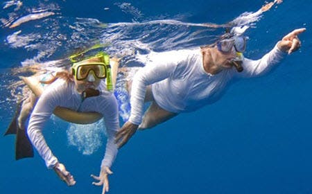 Couple Exploring Underwater World Of Kona