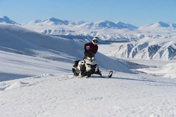 a man riding a snowboard down a snow covered mountain