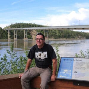 a man standing next to a river