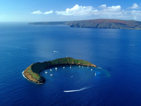 a body of water with Molokini in the background