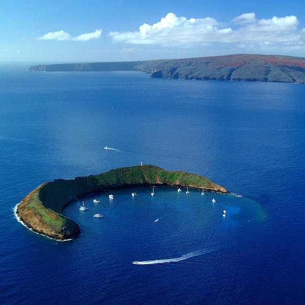 a body of water with Molokini in the background
