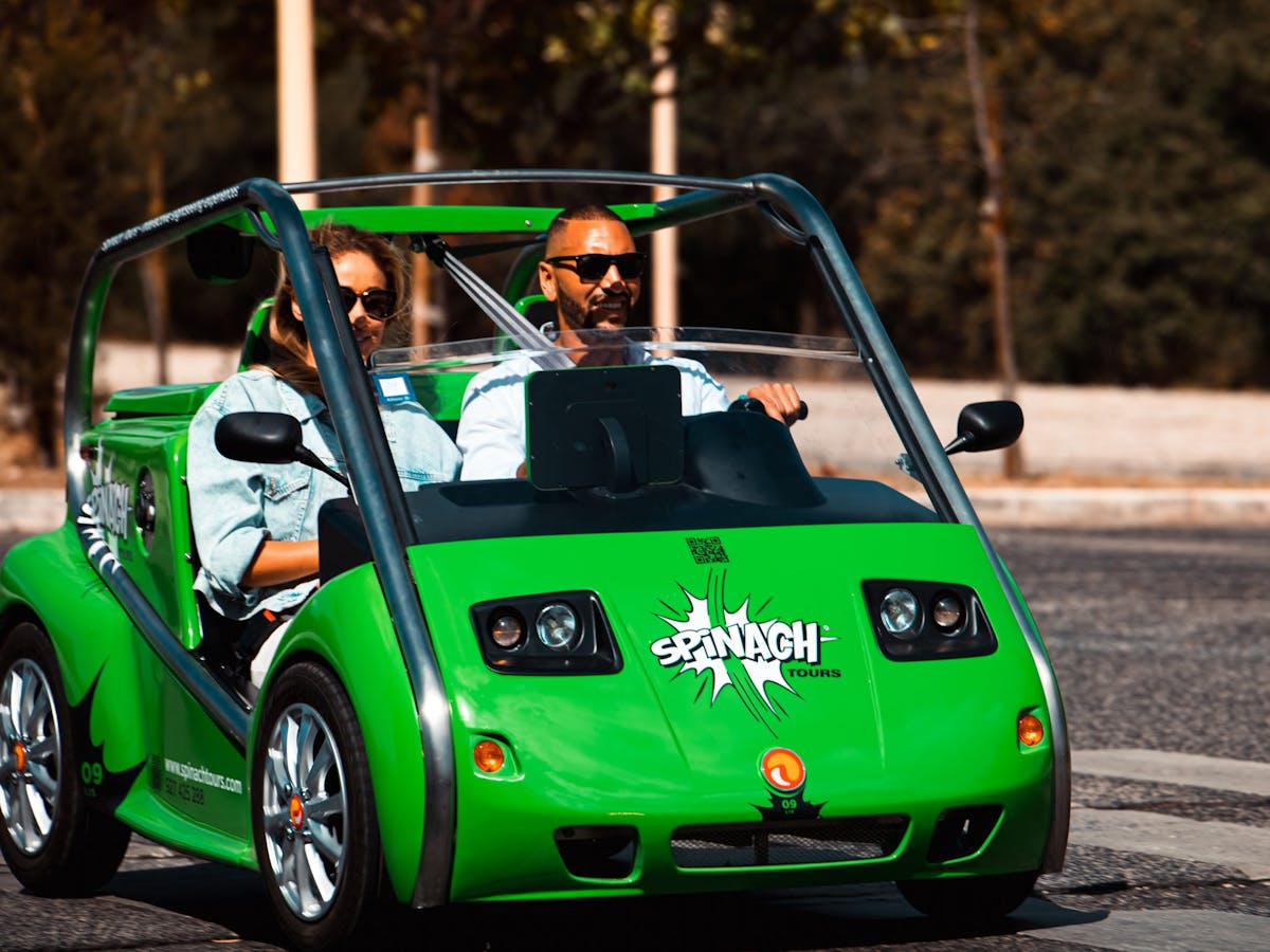 a person riding on the back of a green car