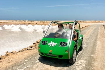 a green car parked on a beach
