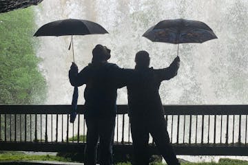 a couple of people that are standing in the rain with an umbrella
