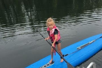 Kid Using Paddle Board On Water