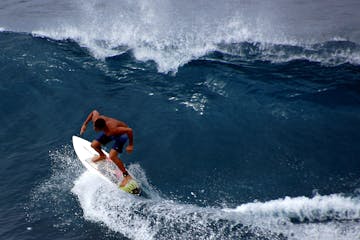 a man riding a wave on a surfboard in the ocean