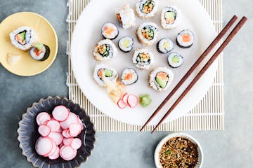 a plate of sushi with chopsticks