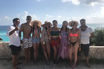 a group of people standing on a beach posing for the camera