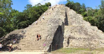 a group of people on a rock with Coba in the background