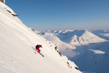 a man skiing down the side of a snow covered mountain