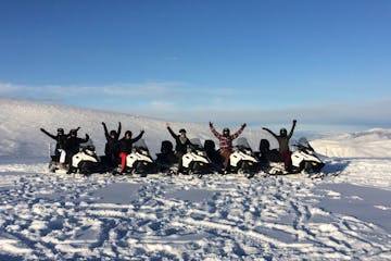 a group of people riding on top of a snow covered slope