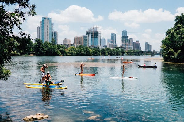 a group of people on stand up paddleboards on a river