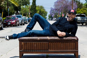 Josh Wolf laying on a piano on a street