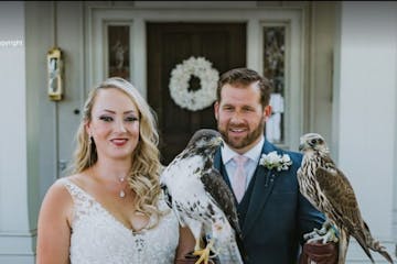 a wedded couple holding birds