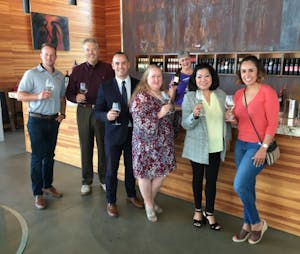 a group of people posing for the camera with wine glasses