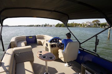 Person driving pontoon boat
