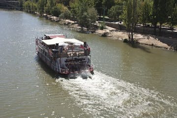 a boat traveling along a river next to a body of water