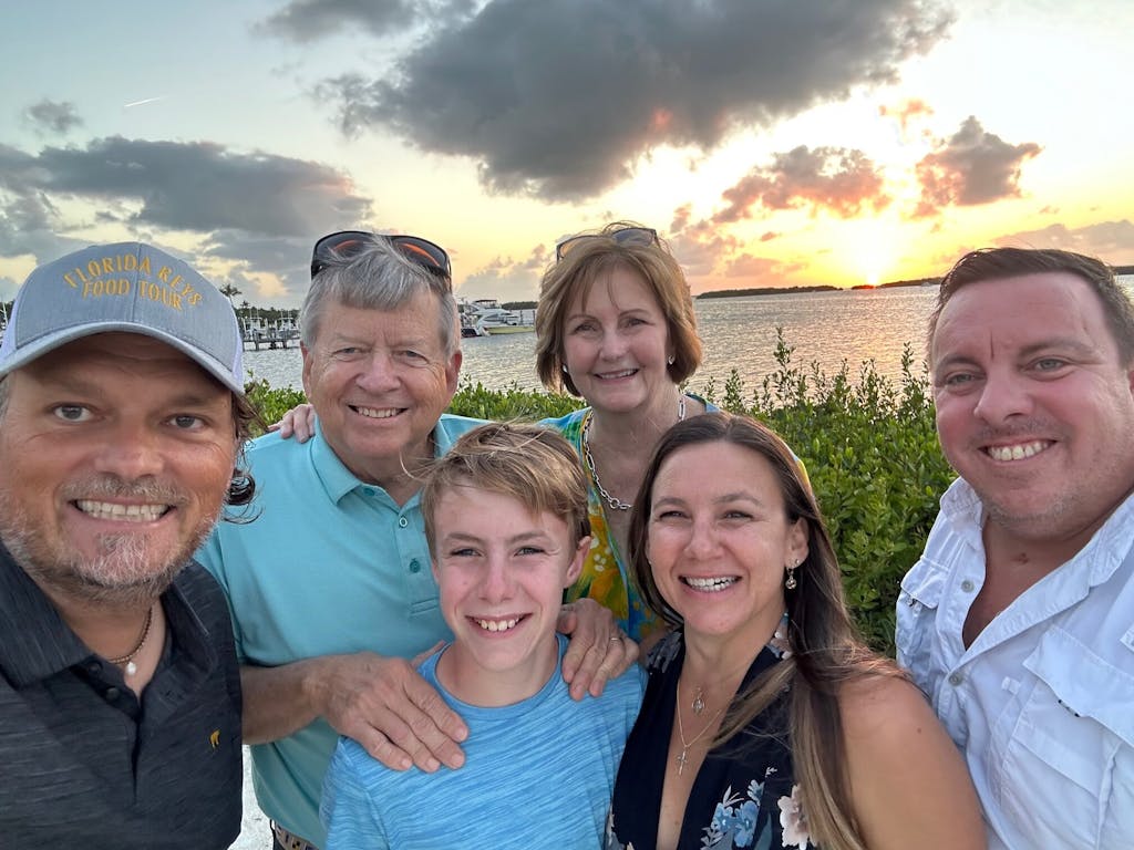a group of people posing for a photo at sunset on the florida keys food tour in islamorada, florida
