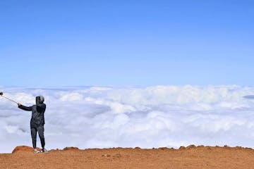 a man taking a selfie on top of a mountain in Maui, Hawaii