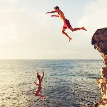 2 people cliff jumping in Maui, Hawaii