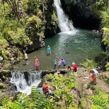 a group of people at a waterfall in in Maui, Hawaii