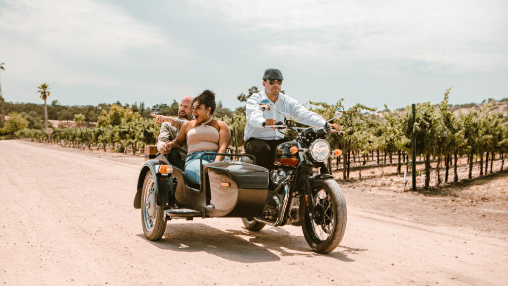 a couple enjoying their sidecar wine tour through the vineyard